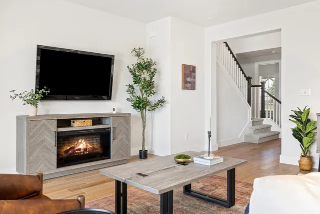 a living room with furniture a flat screen tv and a fireplace
