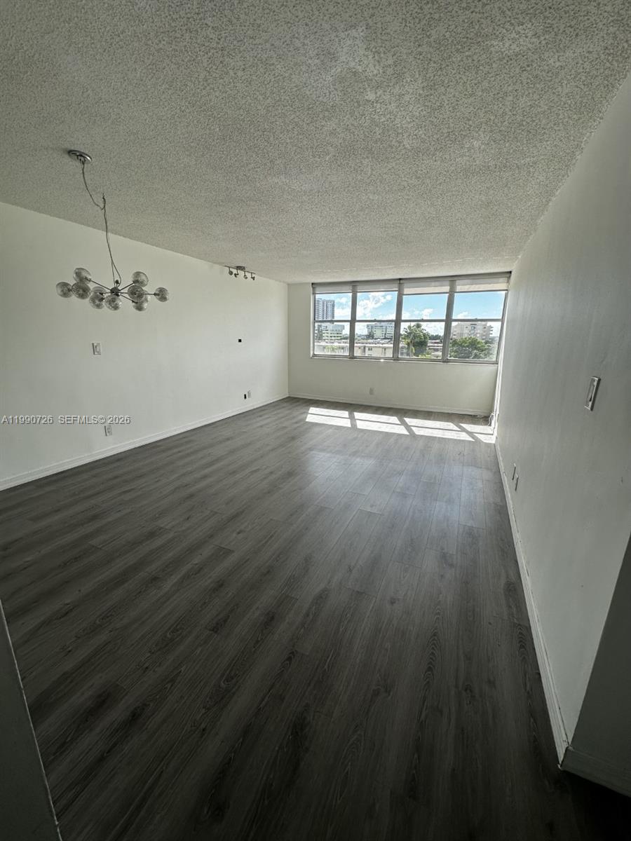 9001 Southwest 77th Avenue, Unit C604 Miami, FL 33156 - Photo 3 of 17 an empty room with wooden floor and windows