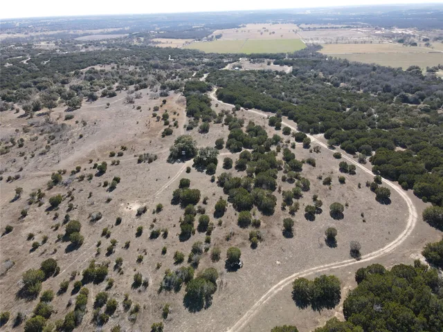 an aerial view of house with yard and mountain view in back