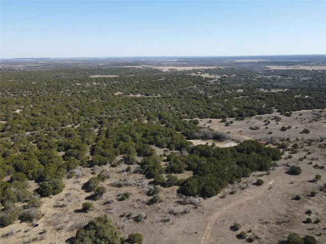 a view of a dry yard with mountains in the background