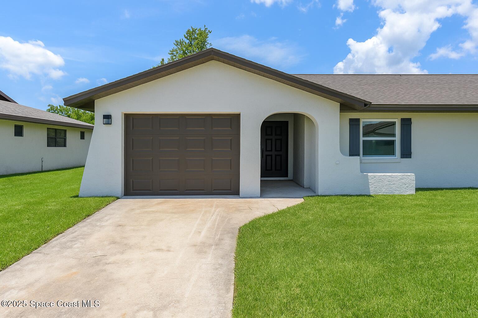 828 Angela Avenue, Unit A Rockledge, FL 32955 - Photo 1 of 31 a front view of a house with a yard and garage
