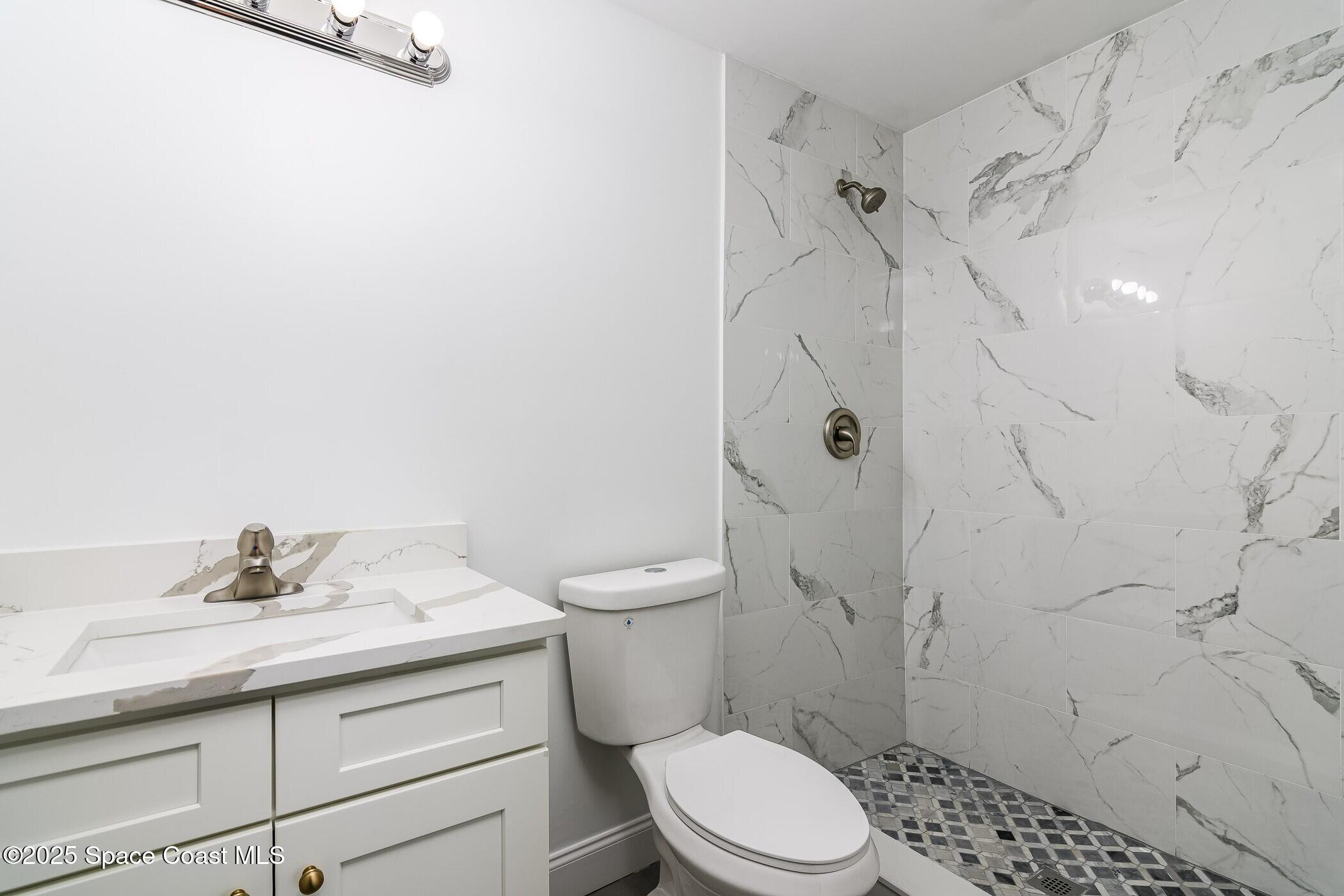 828 Angela Avenue, Unit A Rockledge, FL 32955 - Photo 15 of 31 a bathroom with a sink a toilet and shower