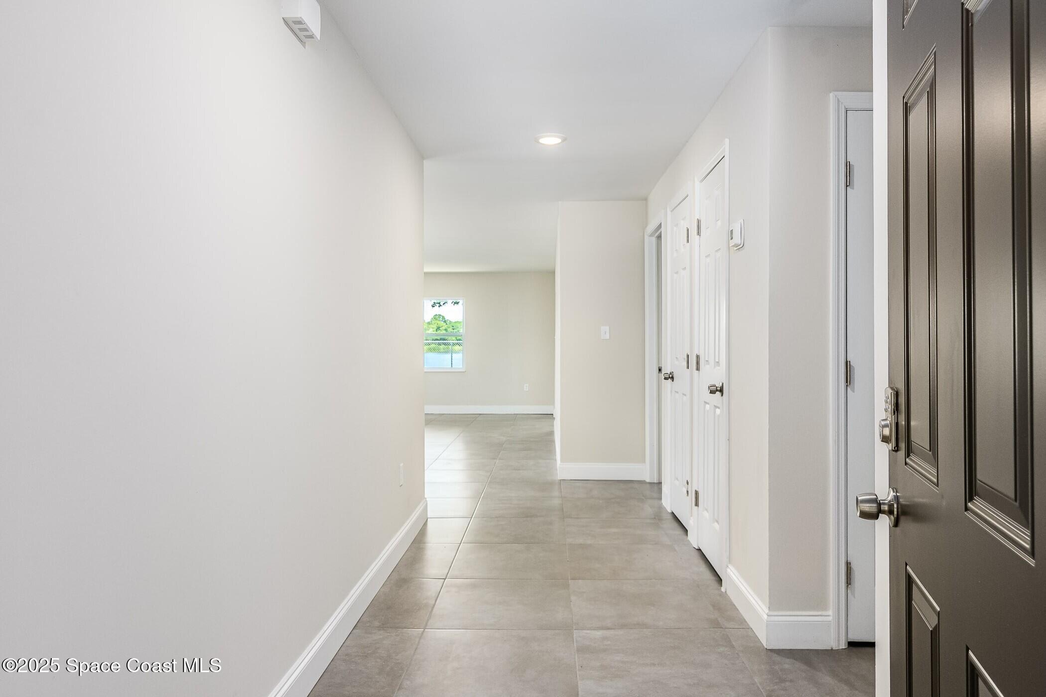 828 Angela Avenue, Unit A Rockledge, FL 32955 - Photo 21 of 31 a view of a hallway with wooden floor and a bathroom