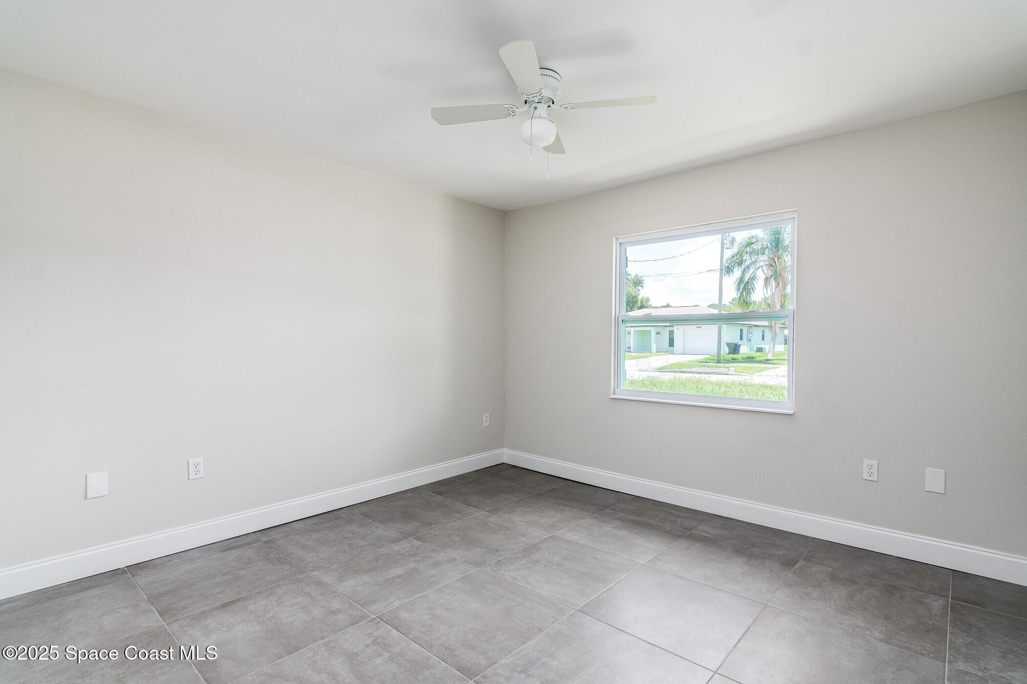 828 Angela Avenue, Unit A Rockledge, FL 32955 - Photo 22 of 31 an empty room with windows and ceiling fan