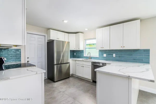 a kitchen with a refrigerator sink and cabinets