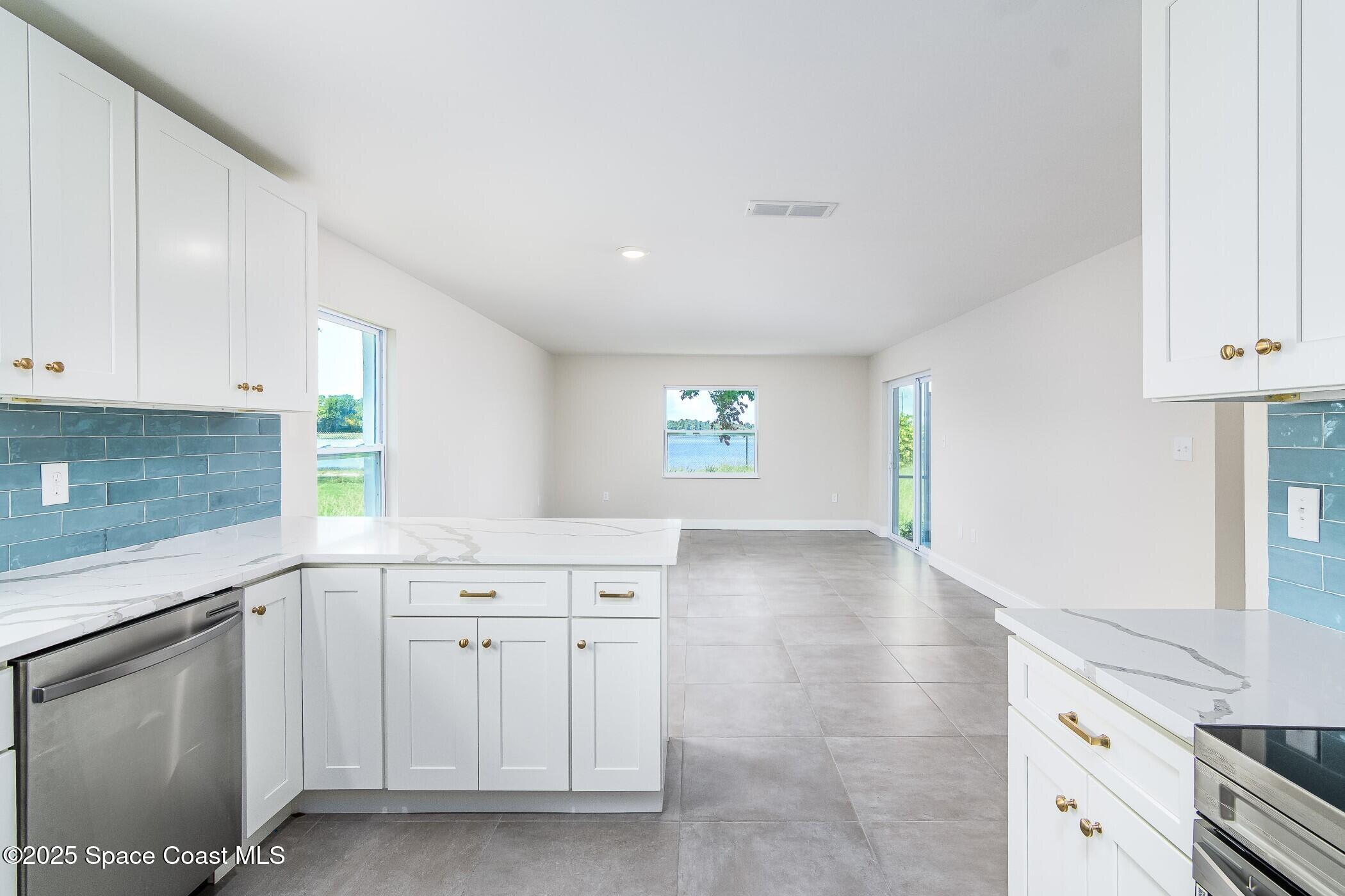 828 Angela Avenue, Unit A Rockledge, FL 32955 - Photo 25 of 31 a kitchen with white cabinets and sink