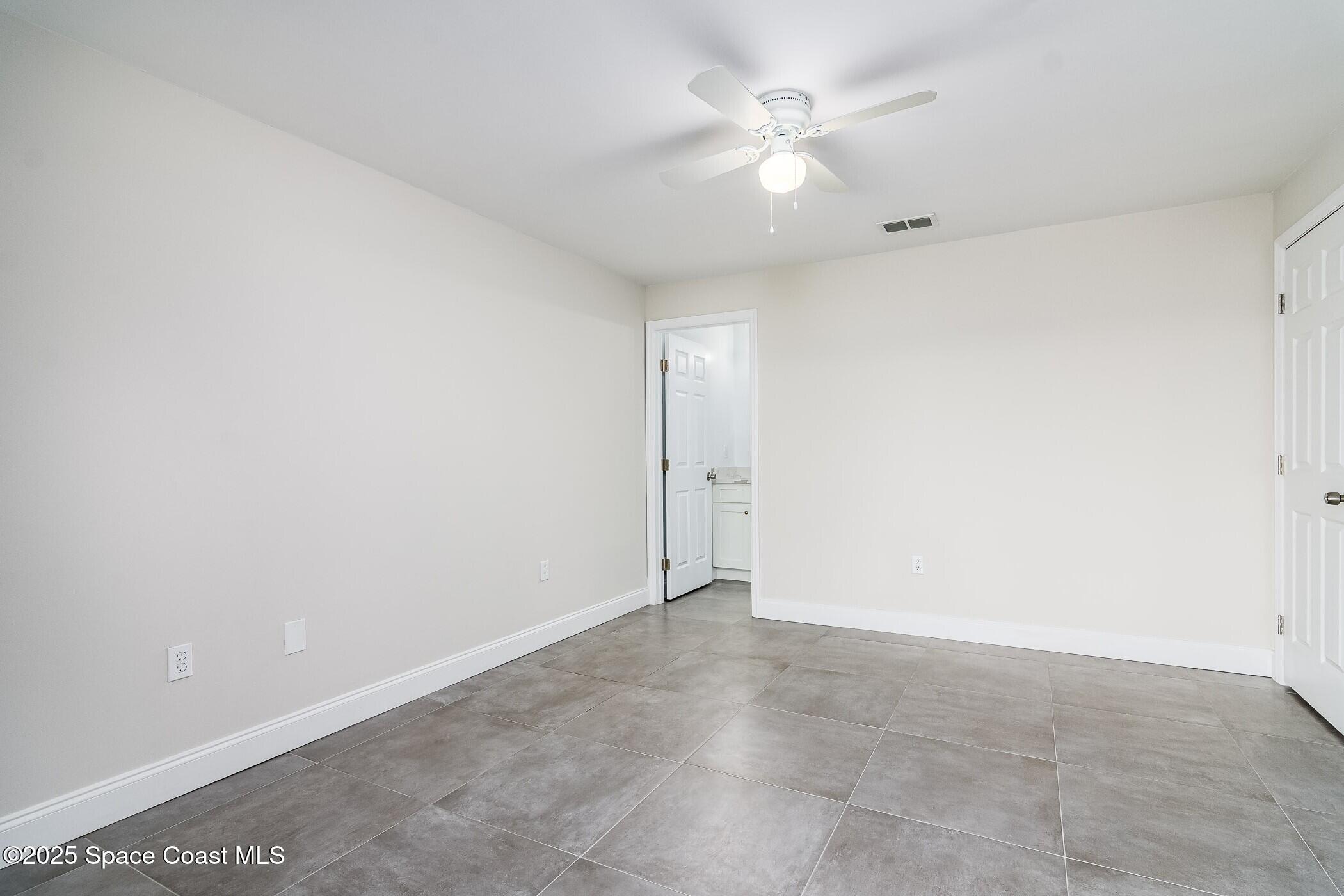 828 Angela Avenue, Unit A Rockledge, FL 32955 - Photo 31 of 31 an empty room with a ceiling fan and a window