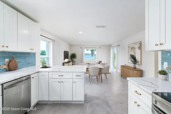 a kitchen with white cabinets and sink