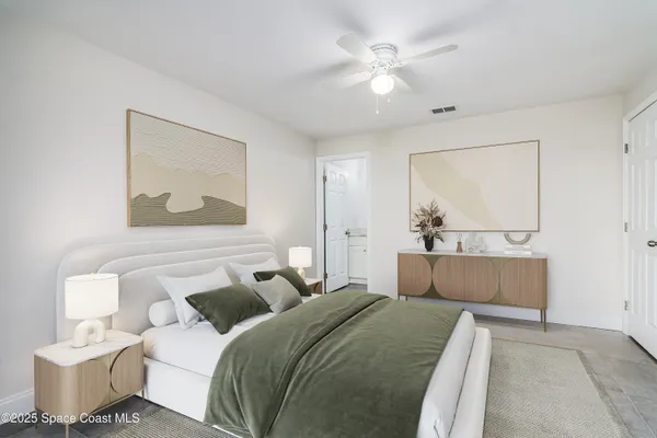 a bedroom with a white bed and a chandelier