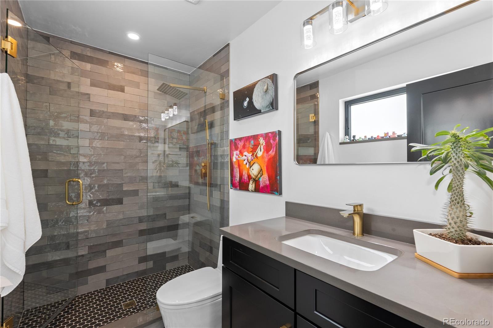 1655 Wolff Street Denver, CO 80204 - Photo 31 of 50 a bathroom with a granite countertop sink a toilet a mirror and shower