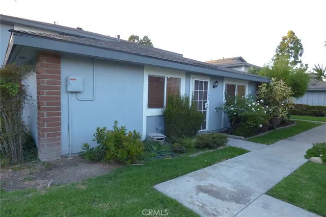 a view of a house with brick walls and a yard with plants