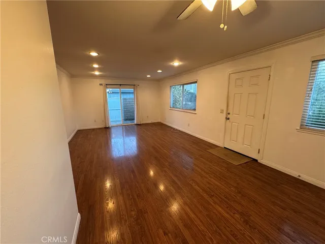 a view of a big room with wooden floor and windows