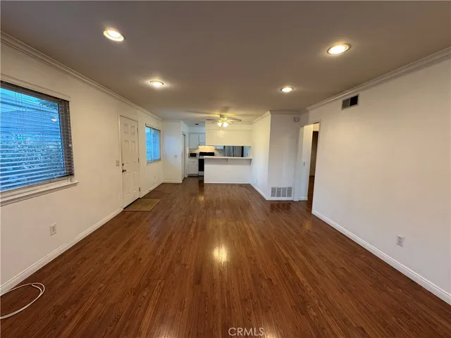 a kitchen with a sink cabinets stainless steel appliances and wooden floor