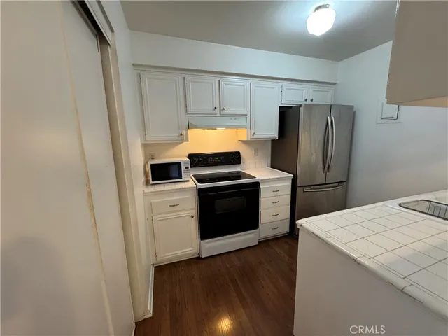a kitchen with wooden cabinets and stainless steel appliances