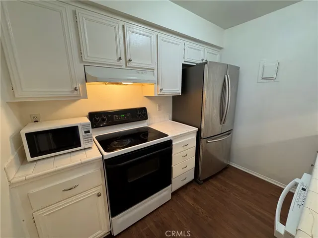a kitchen with a sink a refrigerator and cabinets