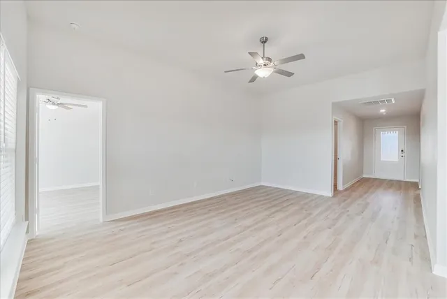 a view of empty room with wooden floor