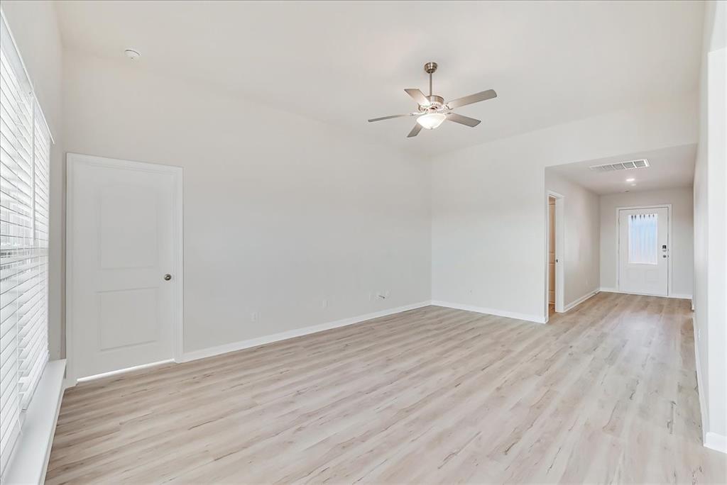115 Sammy Fowler Avenue Venus, TX 76084 - Photo 13 of 34 an empty room with wooden floor fan and windows