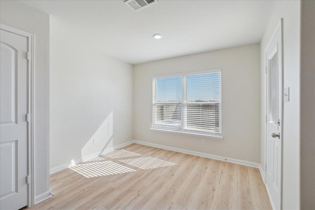 115 Sammy Fowler Avenue Venus, TX 76084 - Photo 22 of 34 a view of an empty room with wooden floor and a window