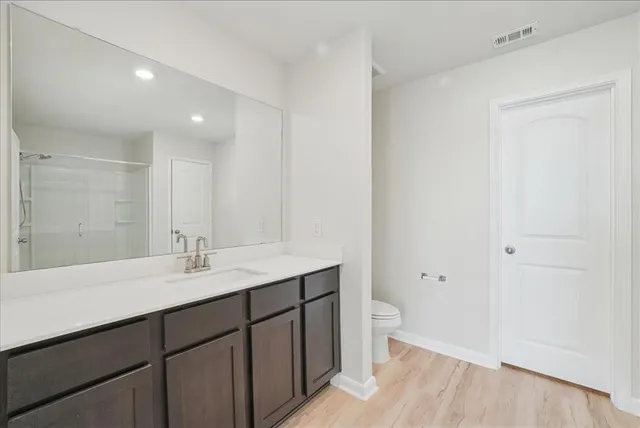 a bathroom with a sink a toilet a shower and a mirror