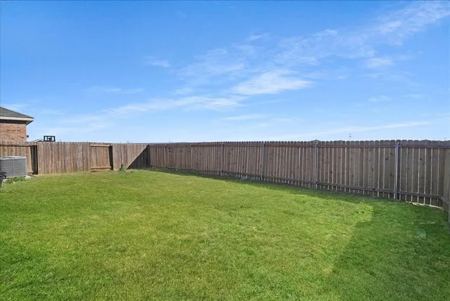 a view of a backyard with wooden fence