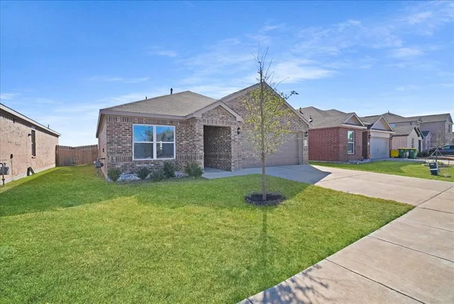 a front view of a house with a garden and yard