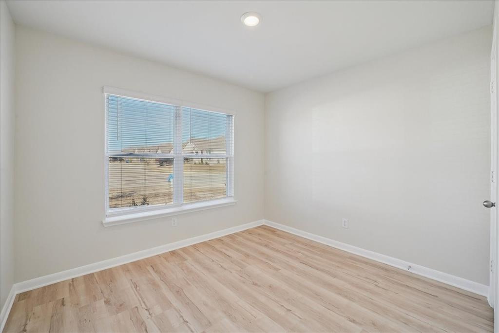115 Sammy Fowler Avenue Venus, TX 76084 - Photo 4 of 34 an empty room with wooden floor and windows