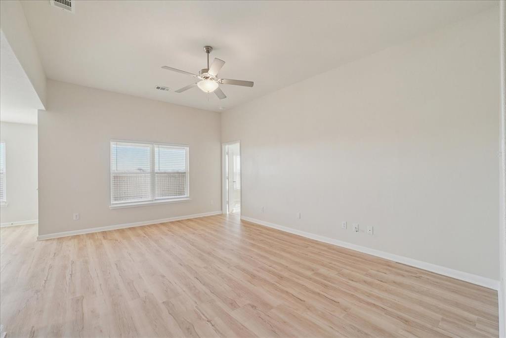 115 Sammy Fowler Avenue Venus, TX 76084 - Photo 10 of 34 an empty room with wooden floor fan and windows
