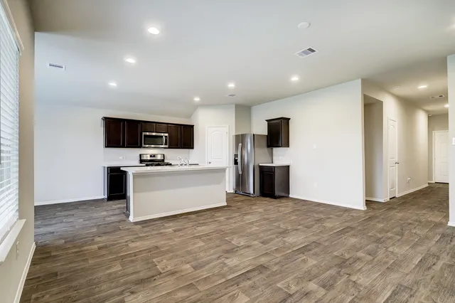 a view of kitchen with microwave cabinets refrigerator and stove