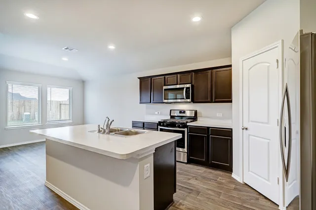 a kitchen with stainless steel appliances a sink stove and refrigerator