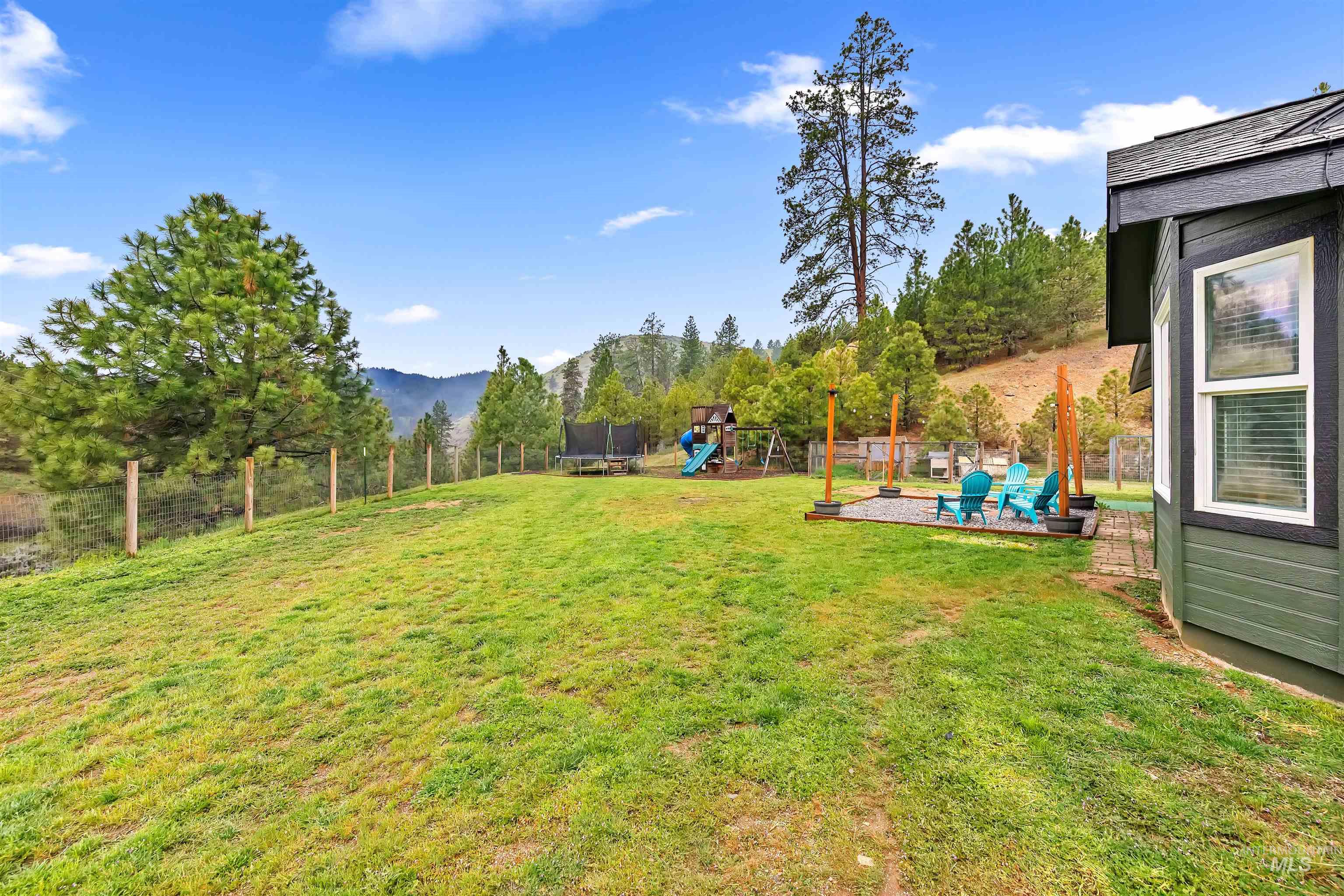 4 Round Up Circle Boise, ID 83716 - Photo 43 of 47 Expansive backyard featuring a green lawn, a dedicated patio space with a gravel surface, and a wire fence