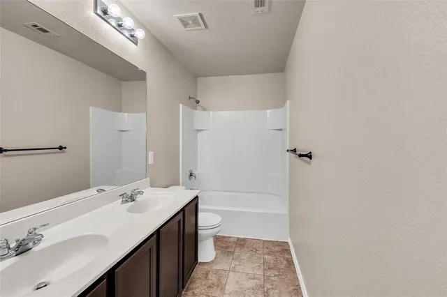a bathroom with a sink a toilet a shower and a mirror
