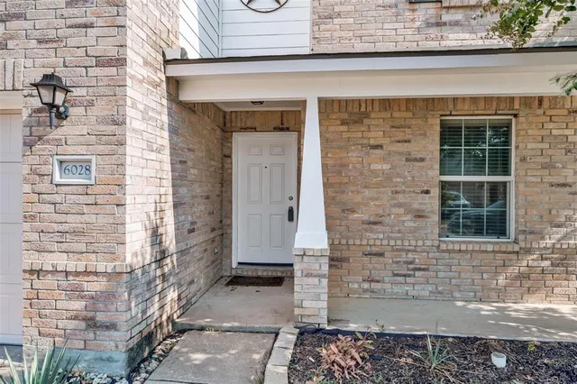 a front view of a house with a brick wall