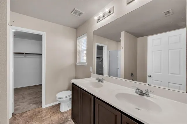 a bathroom with a toilet a sink a mirror and a shower