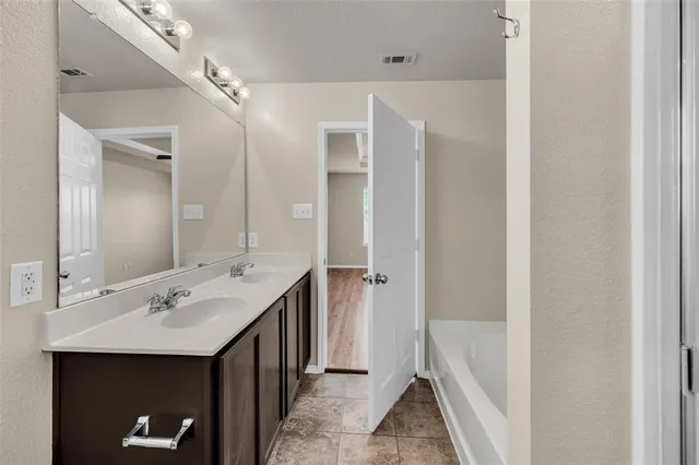 a bathroom with a double vanity sink and mirror