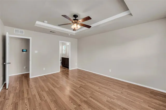 a view of an empty room with wooden floor