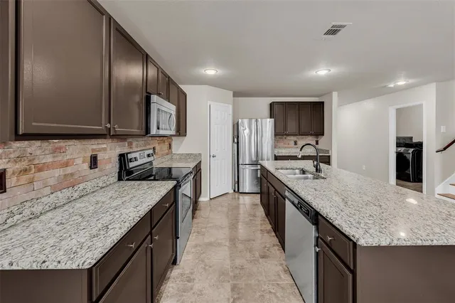 a large kitchen with stainless steel appliances granite countertop plenty wooden cabinets