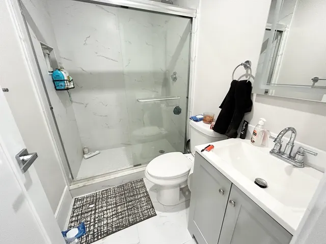 a bathroom with a sink a toilet and shower
