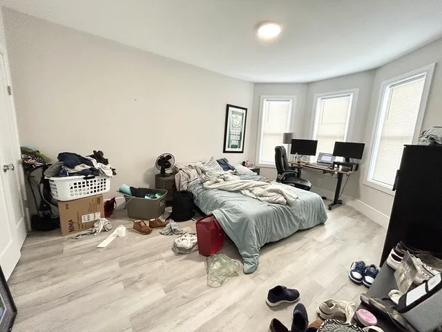 a bedroom with a bed and wooden floor