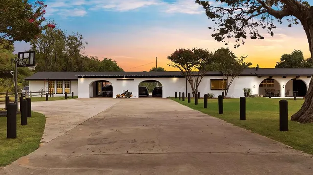 a front view of a house with a garden and trees
