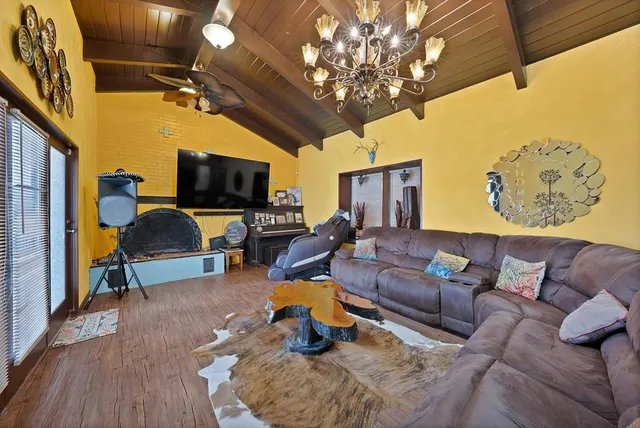 a living room with furniture a flat screen tv and a chandelier