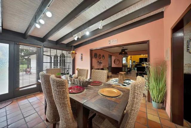 a dining room with furniture a chandelier and wooden floor