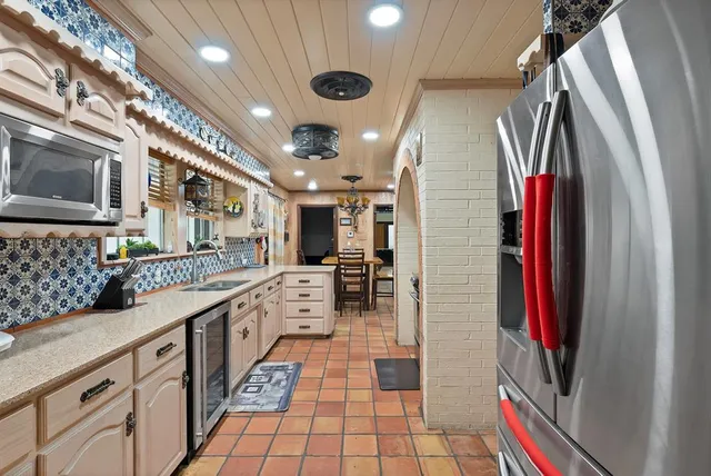a kitchen with stainless steel appliances granite countertop a refrigerator and a stove