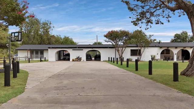 a front view of a house with a garden and trees