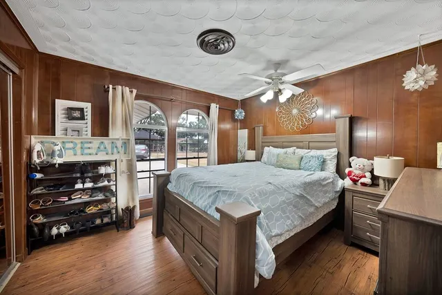 a bed room with a bed mirror and a ceiling fan