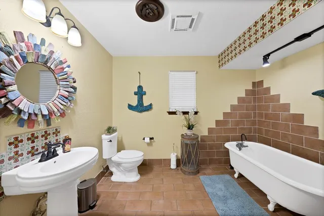 a bathroom with a sink mirror and toilet