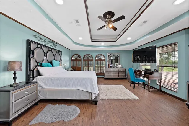 a spacious bedroom with a bed a chandelier and a large window