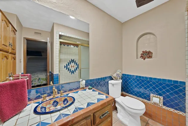 a bathroom with a sink a toilet and a mirror