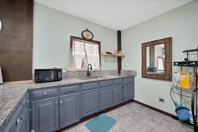 a bathroom with a granite countertop double vanity sink and a mirror