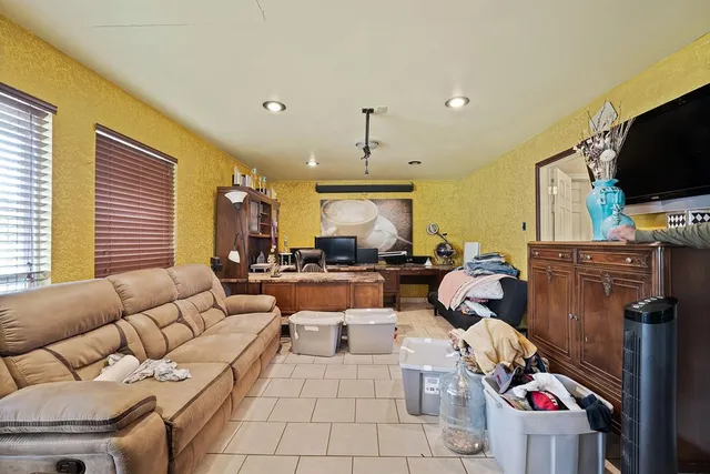 a living room with furniture a flat screen tv and a window