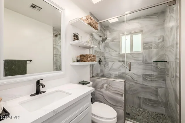 a bedroom with a bed and a large mirror